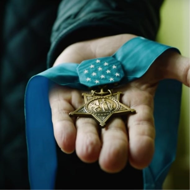 Hand holding the medal of honor