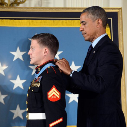 Obama placing a medal on an individual