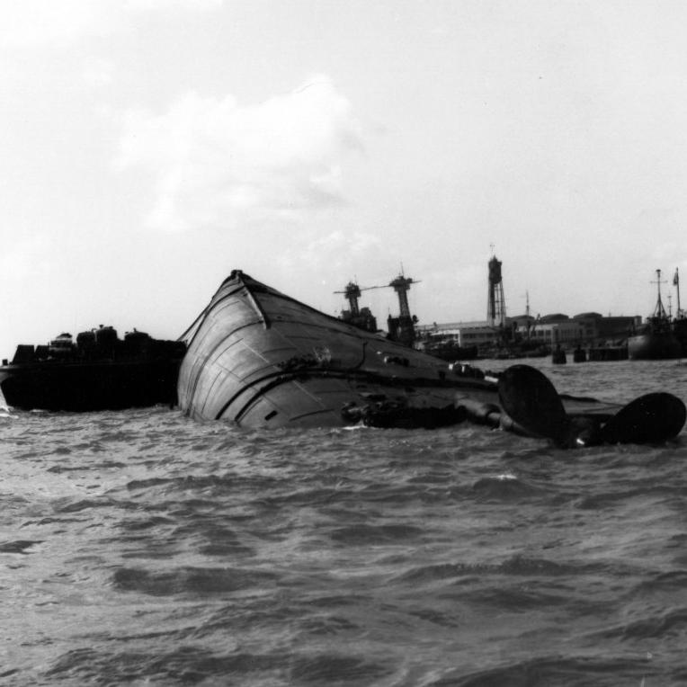 The USS OKLAHOMA, lying capsized in the harbor following the Japanesee attack of December 7, 1941
